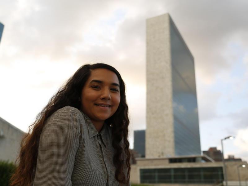 Young woman outdoors with a tall city building behind her