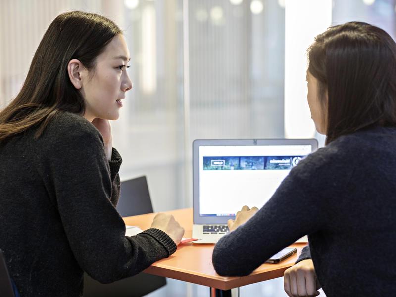 2 women students working together on a laptop